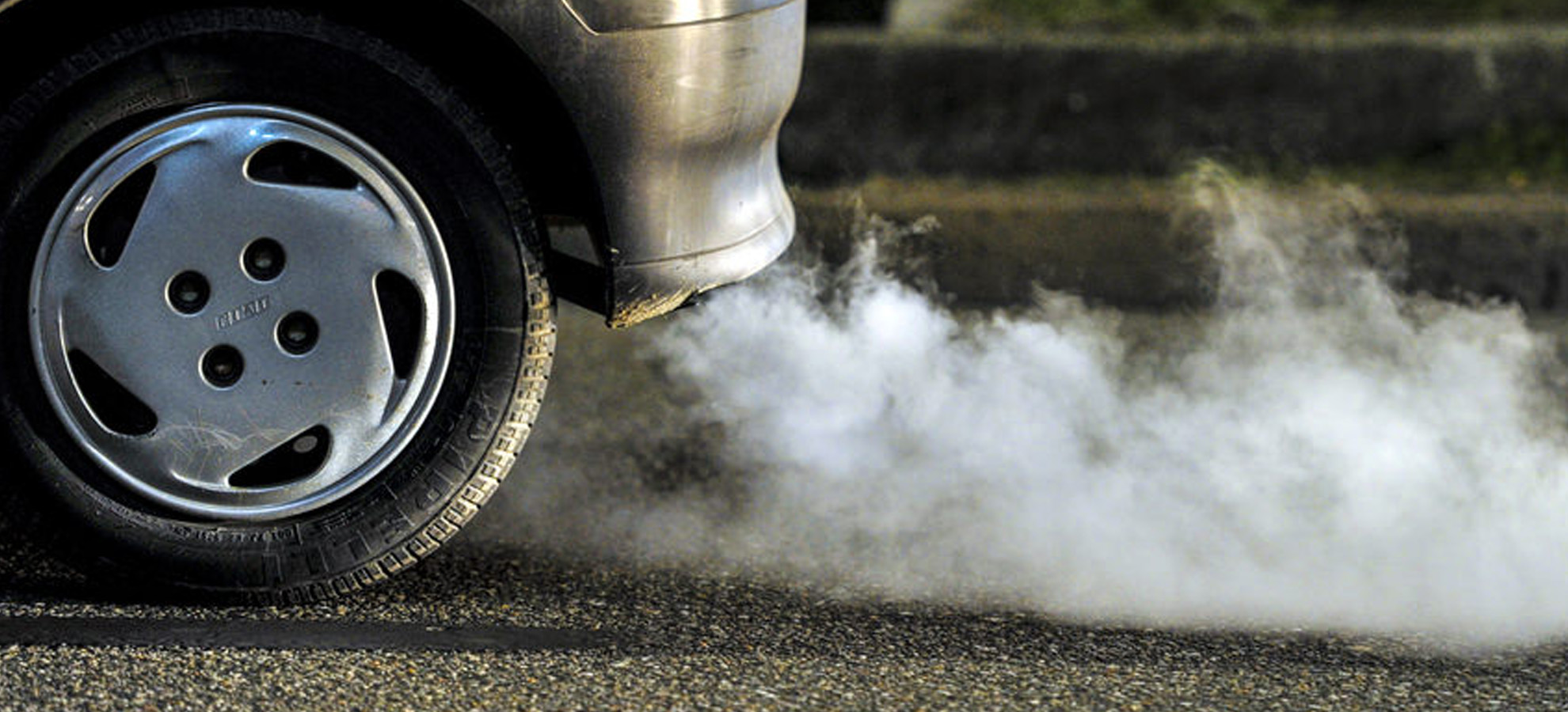 A vehicle with white smoke blowing out of its exhaust - a sign the engine needs replacing
