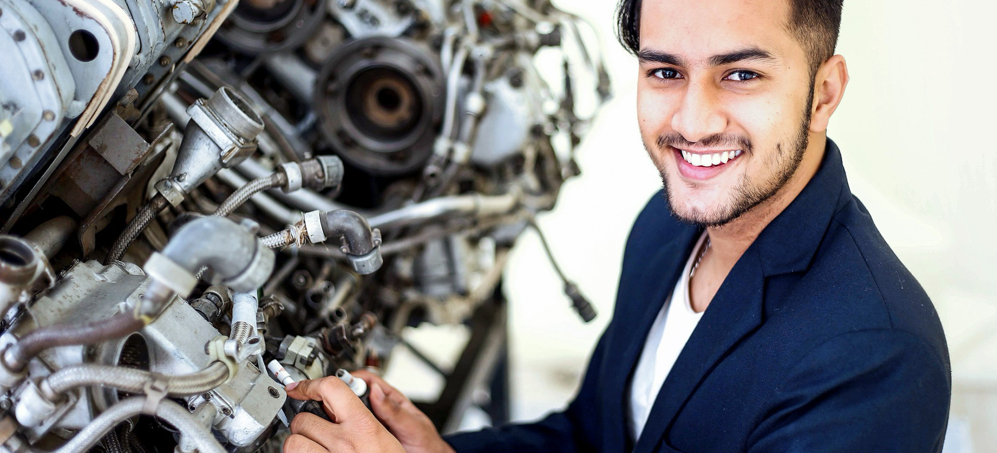 A friendly mechanic who is checking the quality of a used part his team is about to install in a vehicle